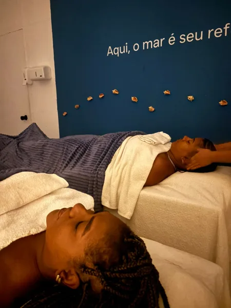 Massagem a dois em macas do Serenna Spa, com parede decorada com conchas ao fundo