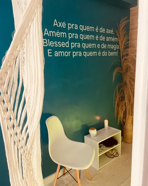 Parede verde-azulada com frase inspiradora e decoração acolhedora no Serenna Spa